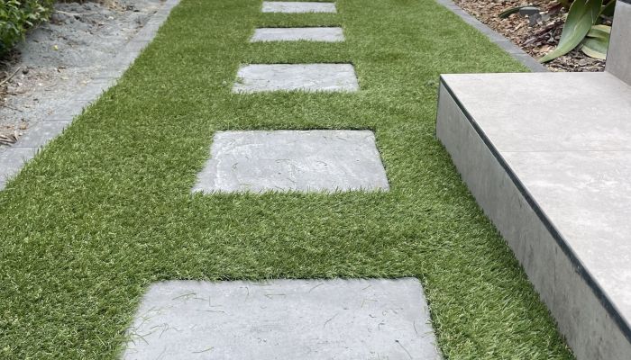 Fake grass installation down side house installation with Paver steppers All About Turf