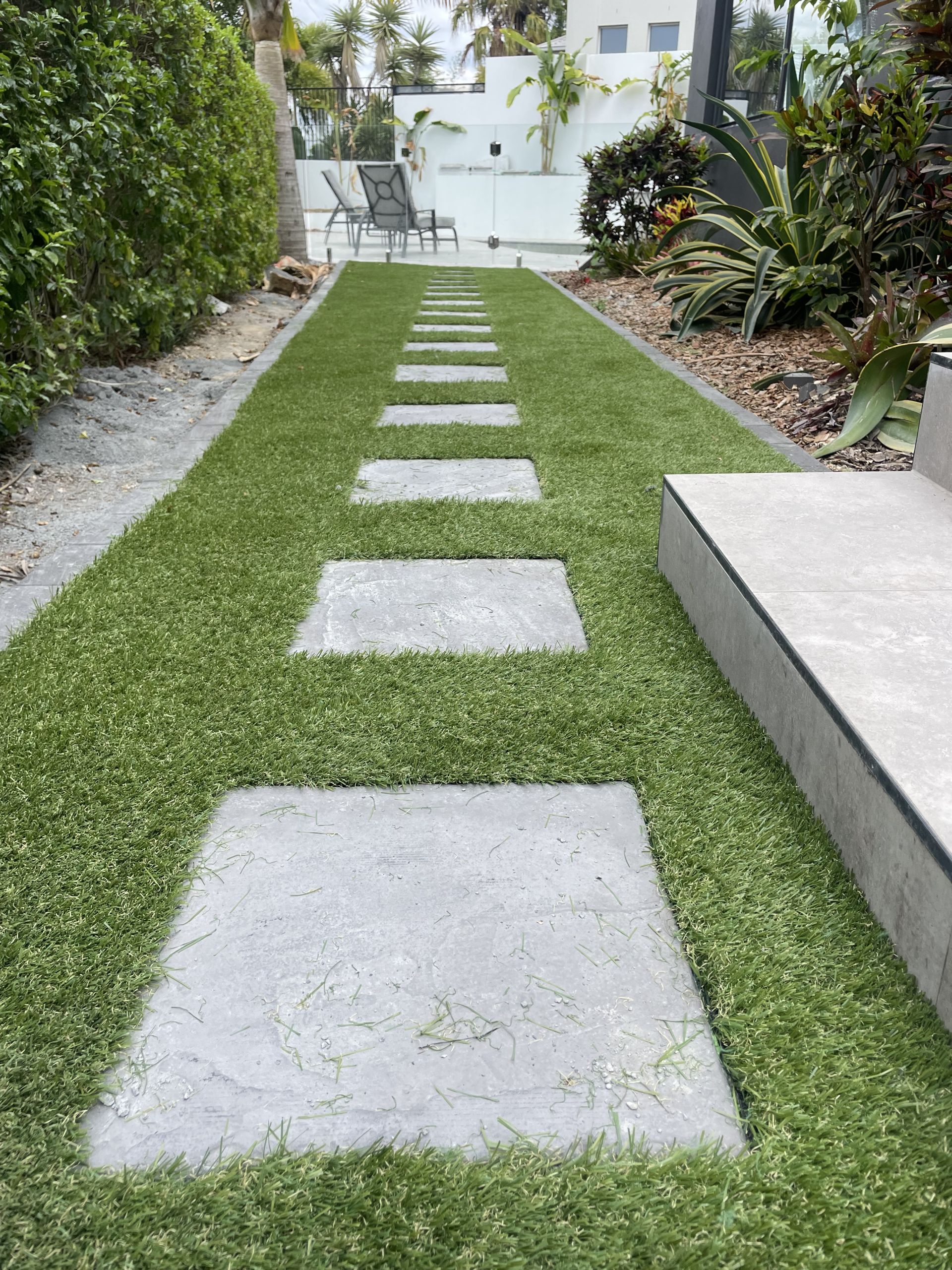 Fake grass installation down side house installation with Paver steppers All About Turf